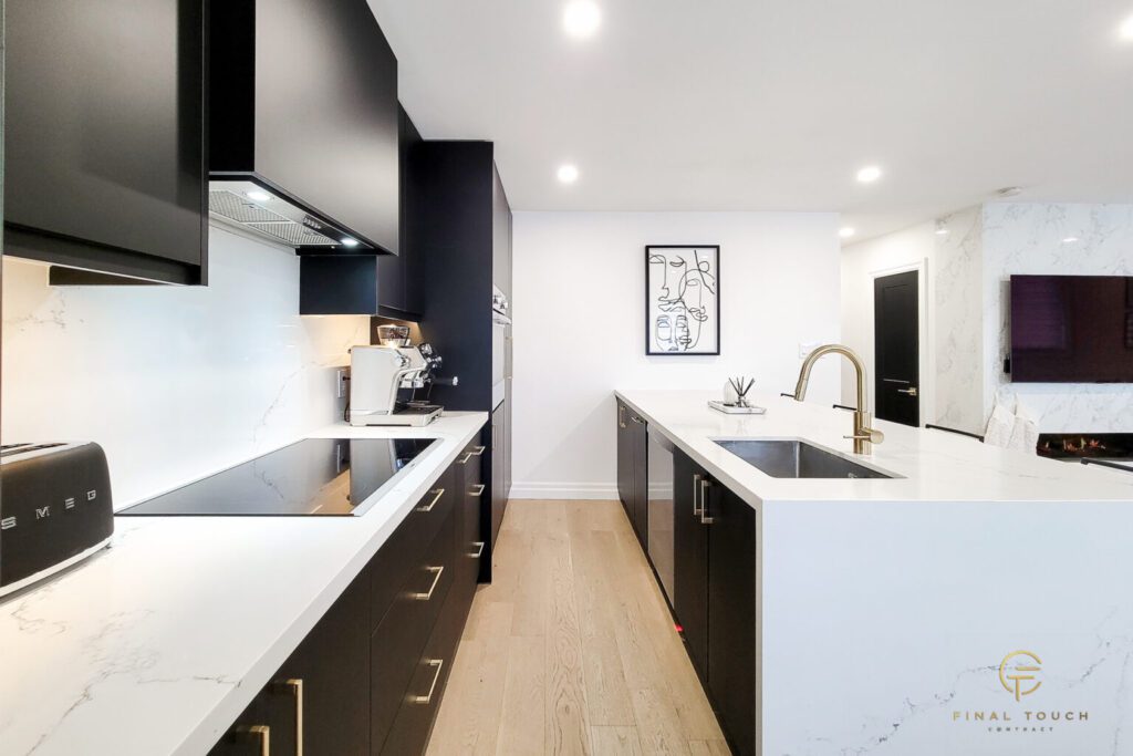 Modern kitchen with sleek black cabinets and white countertops.