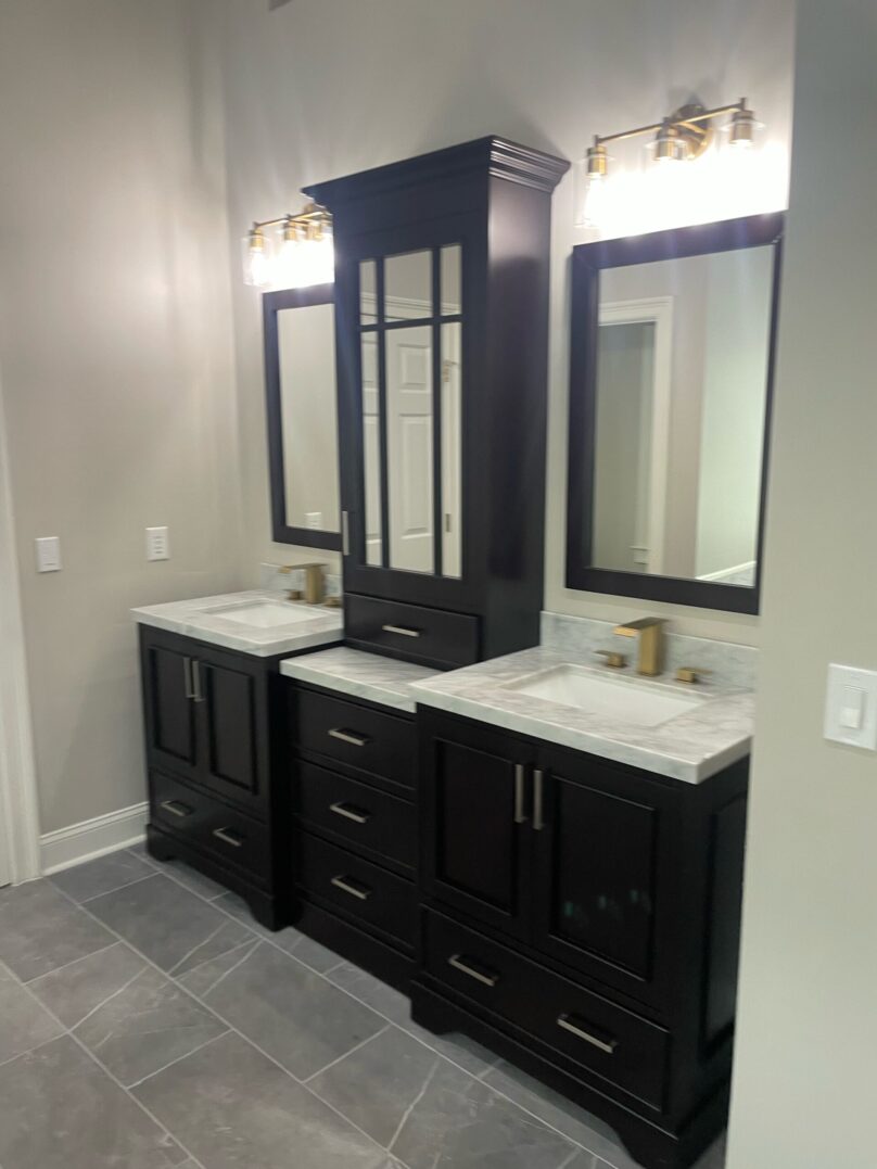 Modern bathroom vanity with dual sinks and dark cabinetry.