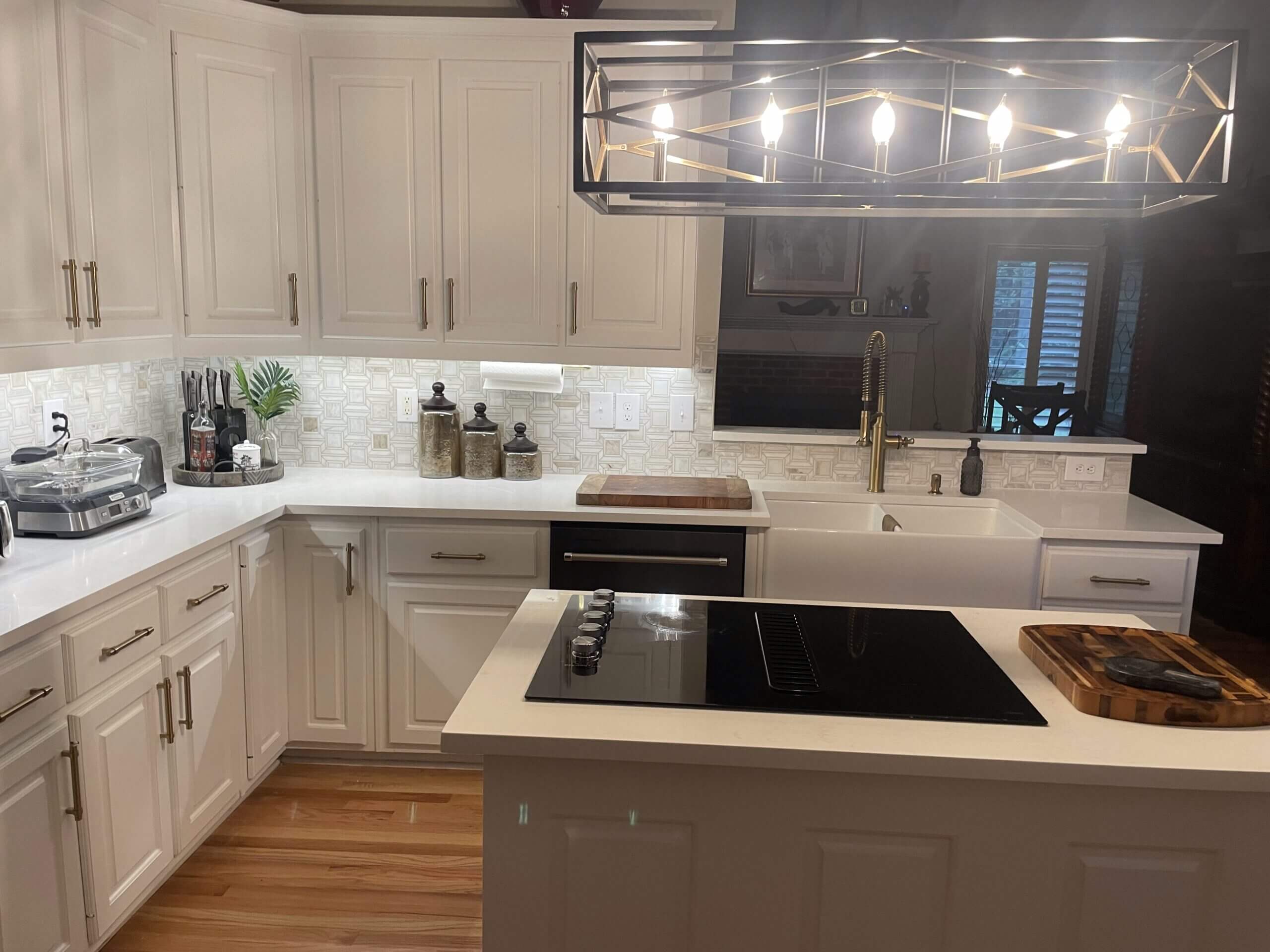 Modern white kitchen with island and pendant lighting.