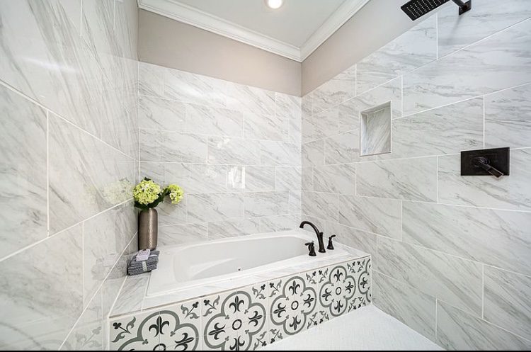 Elegant bathroom with a marble-tiled bathtub and decorative front panel.