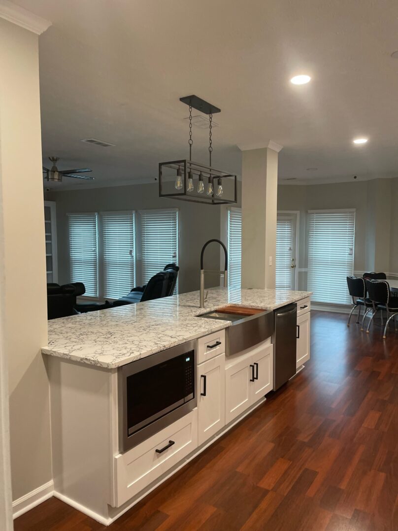 Modern kitchen island with built-in microwave and sleek lighting fixture.