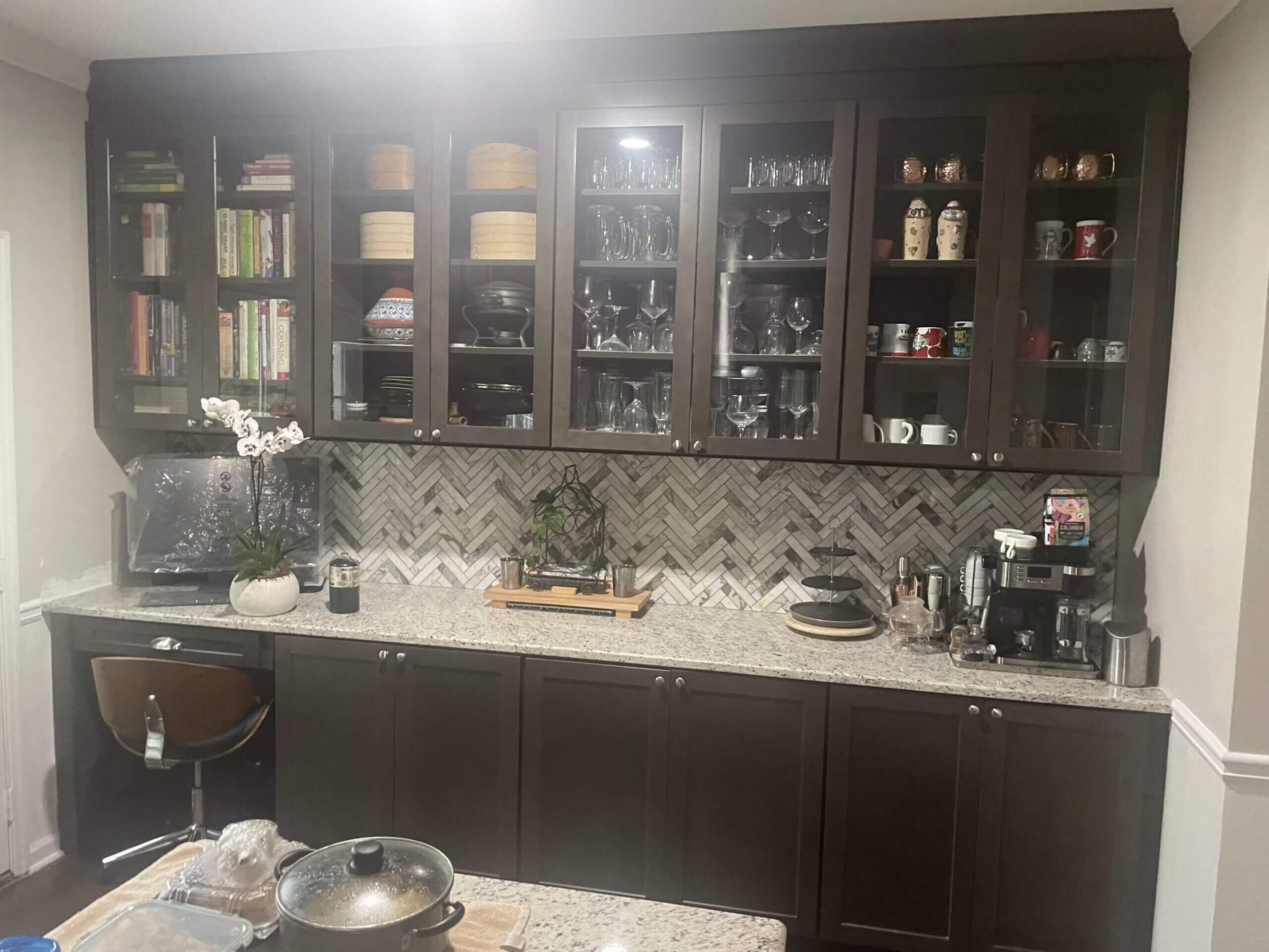 Modern kitchen with dark cabinets and patterned backsplash.