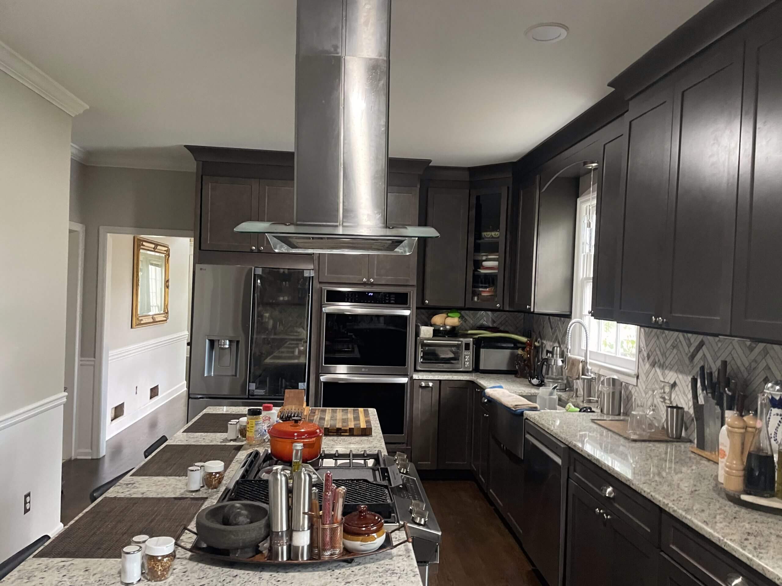 Modern kitchen with dark cabinets and stainless steel appliances.