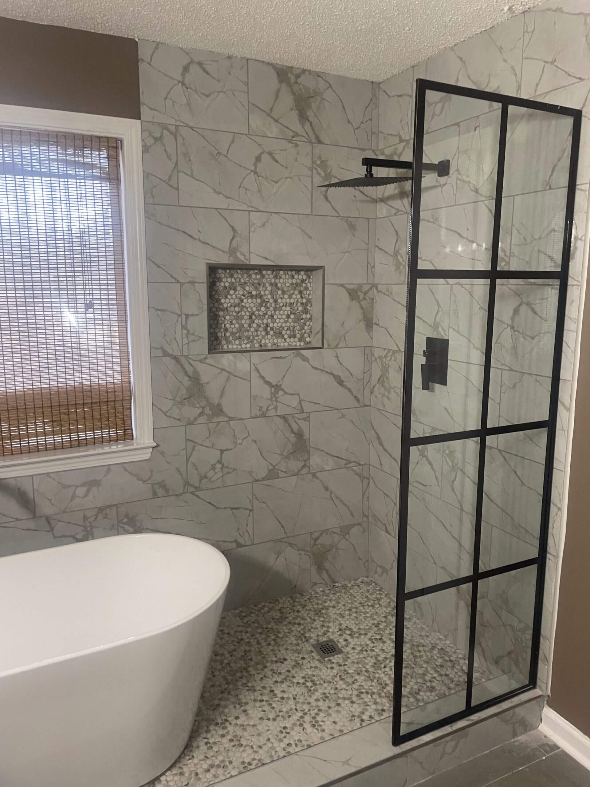 Modern bathroom with a freestanding tub and glass shower enclosure.