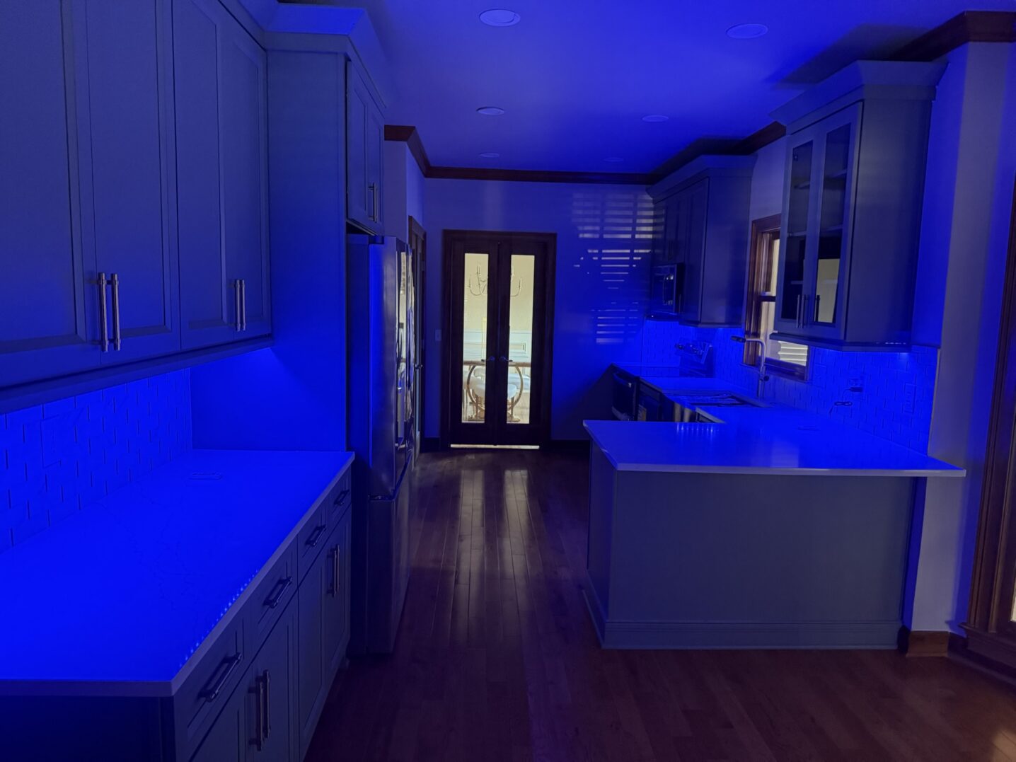 A kitchen illuminated with blue lighting, creating a futuristic ambiance.