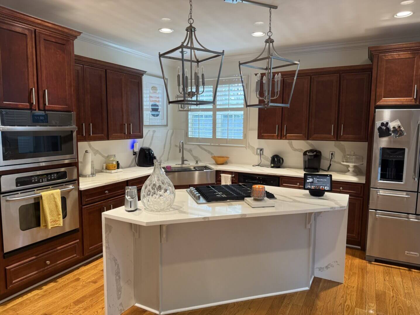 Modern kitchen with a large white island and dark wood cabinets.